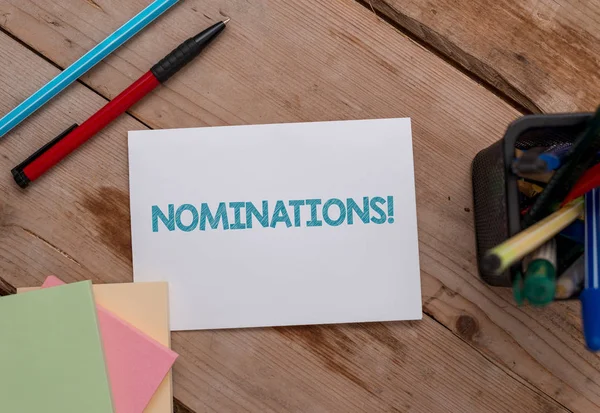 Escritura manual conceptual que muestra nominaciones. Foto de negocios mostrando la acción de nominación o el estado que se nomina para los papeles de premio Nota y estacionario colocado de lado softhued telón de fondo . —  Fotos de Stock