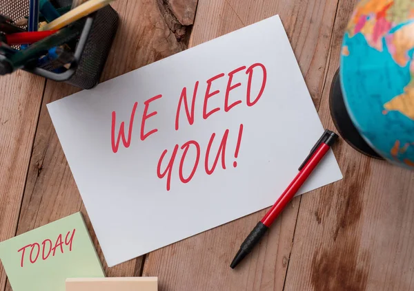 Word writing text We Need You. Business concept for asking someone to work together for certain job or target Writing equipments and sheets with artificial globe on the wooden desk.