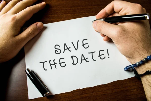 Text sign showing Save The Date. Conceptual photo remember not schedule anything else on this day Close up view male hands writing blank stationary paper pens wooden table. — Stock Photo, Image