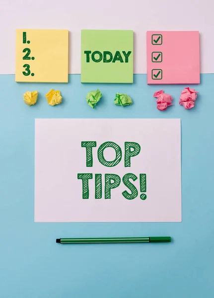Writing note showing Top Tips. Business photo showcasing small but particularly useful piece of practical advice Note papers and stationary placed sideways on top of softhued backdrop.