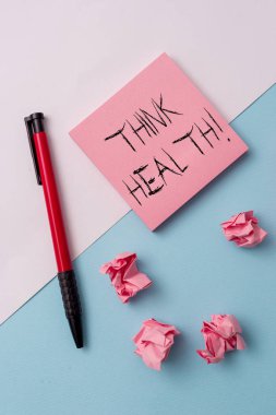 Think Health 'i gösteren bir not yazıyorum. Zihinsel ve sosyal refahın tam fiziksel ve sosyal durumunun iş fotoğrafı gösterimi Not kağıtları ve durgun arka plan üzerine yerleştirilmiş.