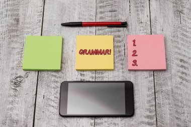 Writing note showing Grammar. Business photo showcasing whole system structure language syntax and morphology Stationary equipment and phone with paper sheets on the wooden desk. clipart