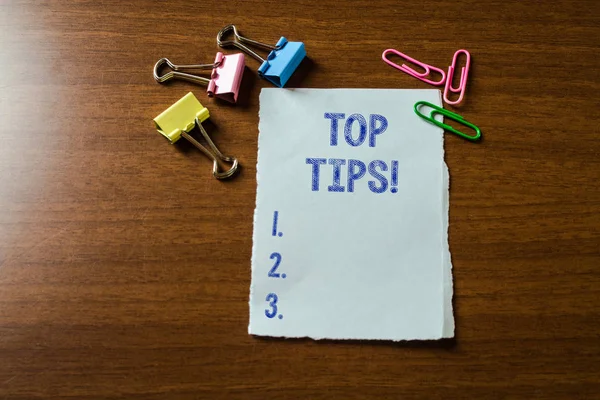 Handgeschreven tekst schrijven top tips. Concept betekenis klein maar bijzonder nuttig stukje praktisch advies blanco stationaire papier set drie gekleurde clips bindmiddel liggend houten tafel. — Stockfoto