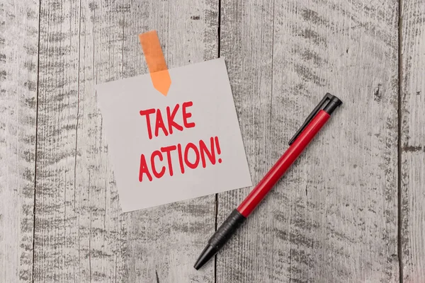 Signo de texto que muestra Take Action. Foto conceptual hacer algo oficial o concertado para lograr el objetivo con el problema Una hoja de papel en blanco llano y un bolígrafo adjunto con madera mesa texturizada . — Foto de Stock