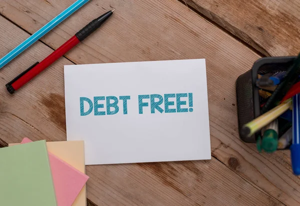 Conceptual hand writing showing Debt Free. Business photo showcasing does not owning any money or things to any individual or companies Note papers and stationary placed sideways softhued backdrop.