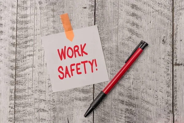 Signo de texto que muestra seguridad en el trabajo. Políticas y procedimientos de fotografía conceptuales para garantizar la salud de los empleados Una hoja de papel en blanco y un bolígrafo adjunto con una mesa con textura de madera . —  Fotos de Stock