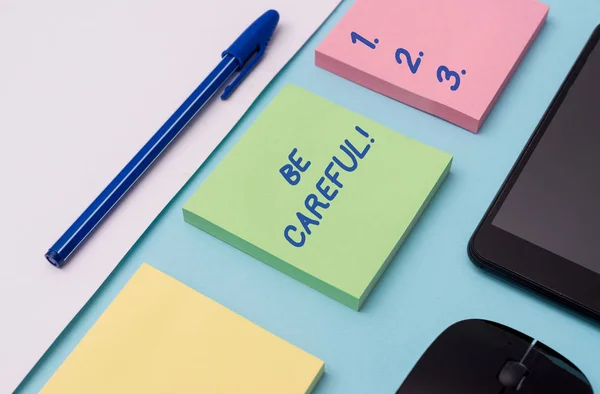 Handwriting text writing Be Careful. Concept meaning making sure of avoiding potential danger mishap or harm Note papers and stationary plus gadgets placed sideways above backdrop. — Stock Photo, Image