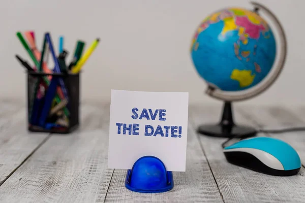 Conceptual hand writing showing Save The Date. Business photo showcasing remember not schedule anything else on this day Stationary and computer mouse with globe on the wooden desk.