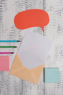 Front view open envelop speech bubble paper sheet ballpoints notepads lying wooden old retro vintage rustic background. Empty text future important events.