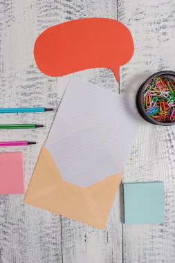 Front view open envelop speech bubble paper sheet ballpoints notepads clips holder lying wooden old retro vintage rustic background. Empty text future important events.