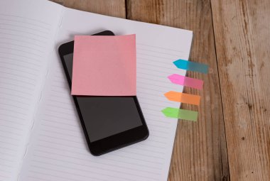 Çizgili sert kapak notu kitap akıllı telefon yapışkan not dört renkli ok afiş retro vintage rustik eski koyu ahşap ahşap arka plan Önemli gelecek olaylar eklenmiş
