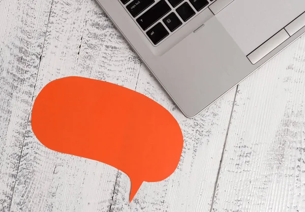 Basta canto moderno aberto laptop bolha de fala em branco voltada para baixo deitado mesa de madeira vintage. Computador pessoal que descansa velha mesa de madeira. Texto vazio para promoção — Fotografia de Stock