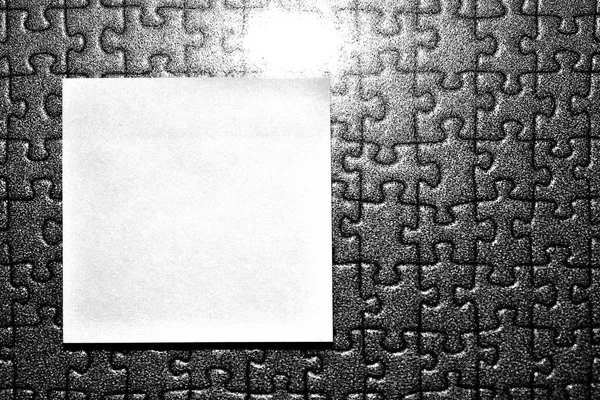 Rectangular note paper attached to puzzle shape background. A piece of square sheet use to give notation stick to textured backdrop. photo about leaving message