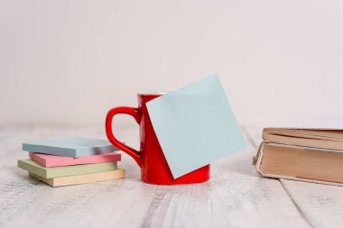 Ön görünüm kahve fincan ıstıraç sıcak içecekler boş renkli yapışkan not kitapları yığılmış not pedleri retro vintage rustik eski masa arka plan yalan. Soyut tasarım. Boş not