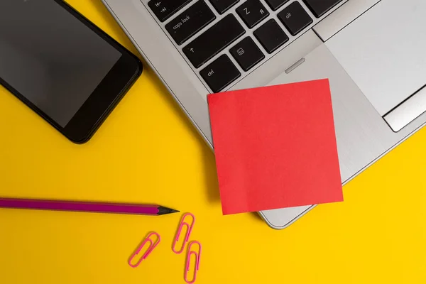 Parte vista moderno laptop metálico em branco nota pegajosa clipes de lápis de smartphone fundo colorido. Computador pessoal pequena folha de papel vazio mensagem de texto — Fotografia de Stock