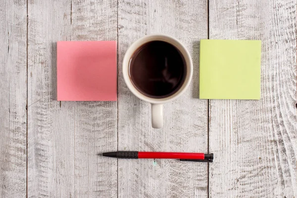 Schreibgeräte neben Tasse Kaffee auf dem hölzernen Hintergrund. leeres Papier neben einem Becher mit Getränken über dem Tisch. künstlerische Art und Weise beim Arrangieren von flachen Lagen Fotografie — Stockfoto