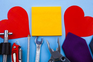 Front view working tools. Wrench clamps screwdriver tie middle note pads two paper hearts good advertisement house repair Fathers Day. Man repairing damages at home clipart