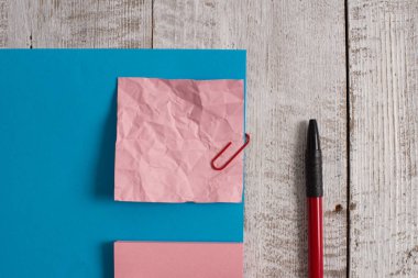 Buruşuk not kağıdı ve ahşap masa nın üzerinde boş karton. Kırışıklık sayfası artı eğik pozisyonda klasik arka plan sabit sopa. Düz sanatsal yolu fotoğraf bırakır