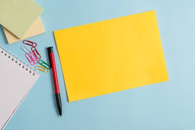 Düz karton ve pastel fon üzerine yerleştirilen yazma ekipmanları. Kağıt artı modern desensiz arka plan sabit sopa. Düz sanatsal yolu fotoğraf bırakır