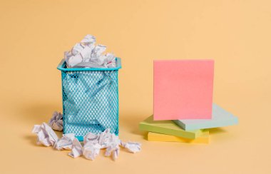 Buruşuk kağıt ve çöp kutusunda sabit. Yazı ekipmanı artı çöp kutusuna yerleştirilen artıkları içeren not sayfası. Ofis çöp saklanan notasyon karton da kalem