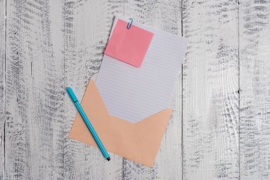 Front view open colored rectangular envelope blank sheet paper sticky note ballpoint lying retro vintage rustic old lumber timber table background. Empty text letter