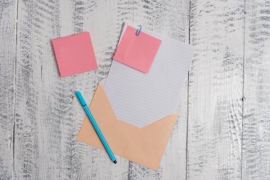 Front view open colored rectangular envelope blank sheet paper sticky note ballpoint lying retro vintage rustic old lumber timber table background. Empty text letter