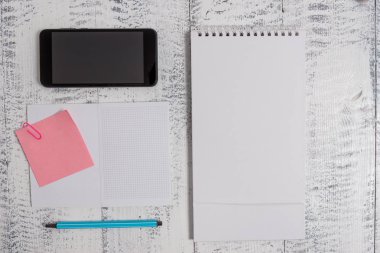 Yakın ön görünüm kare açık spiral defter marker yapışkan not klip akıllı telefon ahşap retro vintage rustik eski arka plan yalan. Metni boş alır önemli olaylar