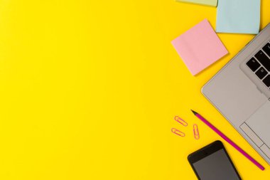 Bölüm görünümü ince trendy gümüş açık dizüstü kalem kalem kalem vurgulayıcı klipleri not defterleri akıllı telefon renkli arka plan. Çalışma istasyonu ev ofis okul stüdyosu