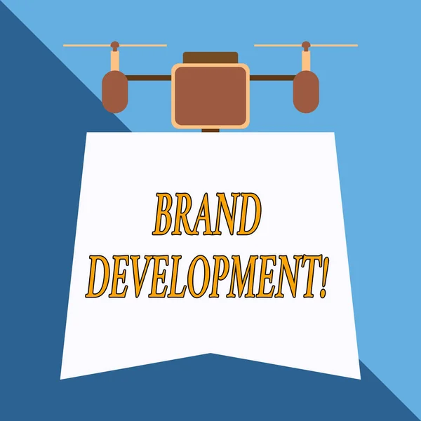Writing note showing Brand Development. Business photo showcasing Defining the product to excel in the market Promoting Drone holding downwards banner. Geometrical abstract background design.