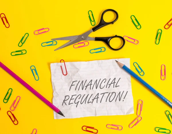 金融規制を示すメモを書く。金融システムの完全性を維持することを目指すビジネス写真展示ストライプ紙シートはさみ鉛筆クリップ色の背景. — ストック写真