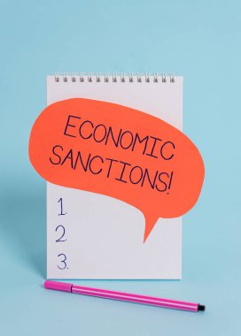 Handwriting text writing Economic Sanctions. Concept meaning Penalty Punishment levied on another country Trade war Standing blank spiral notepad speech bubble pen lying cool background.