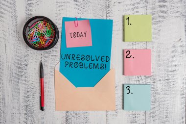 Çözülmemiş sorunları gösteren Not yazma. İş fotoğrafı bu sorgular vitrine kimse cevap verebilir yanıtlanabilir sorular zarf harfi yapışkan not tükenmez kalem ahşap arka planda klipler.