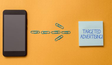 Hedeflenen reklam gösteren kavramsal el yazma. İş fotoğraf metin online reklam reklamları tüketici aktivitesine dayalı renkli boş yapışkan not klipleri Smartphone Cool pastel arka plan.