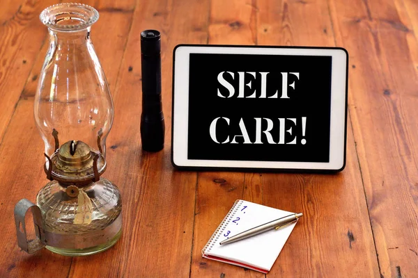 Word writing text Self Care. Business concept for practice of taking action preserve or improve ones own health Writing equipments placed next to gadget plus a classic vintage lantern. — Stockfoto