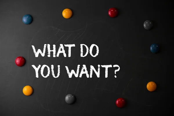 Text sign showing What Do You Want Question. Conceptual photo say or write in order to ask demonstrating about something Round Flat shape stones with same sizes stick to old chalk black board.
