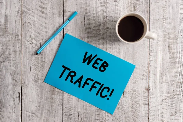 Conceptual hand writing showing Web Traffic. Business photo showcasing amount of data sent and received by visitors to website Pastel Colour paper and pen with coffee cup on wooden table. — Stok fotoğraf