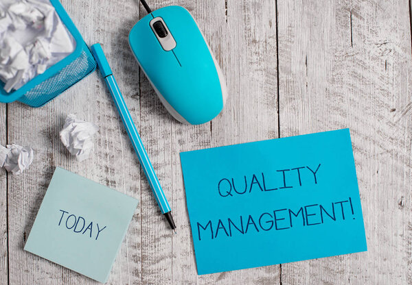 Conceptual hand writing showing Quality Management. Business photo showcasing Maintain Excellence Level High Standard Product Services Crumpled paper in bin and computer mouse on wooden backdrop.