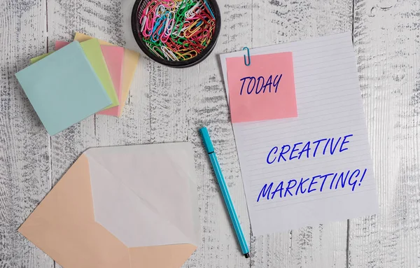 Hand SKRIFTS text skriver Creative Marketing. Koncept som innebär kampanjer för att uppfylla kraven på annonsering kuvertet papper klibbiga antecknings block penna klipp innehavaren trä bakgrund. — Stockfoto