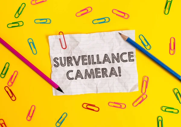 Conceptual hand writing showing Surveillance Camera. Business photo showcasing Closed Circuit Television transmit signal on monitors Blank crushed paper sheet message pencils colored background. — Stock Photo, Image