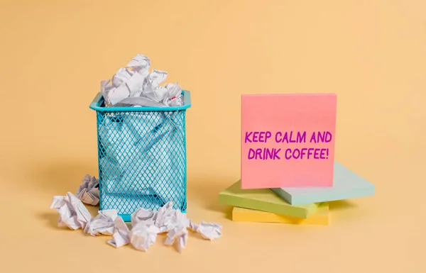 Conceptual hand writing showing Keep Calm And Drink Coffee. Business photo showcasing encourage demonstrating to enjoy caffeine drink and relax crumpled paper and stationary paper placed in the trash