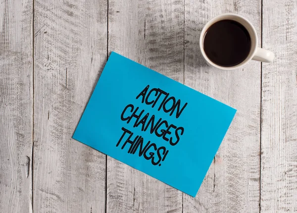 Text sign showing Action Changes Things. Conceptual photo start doing something against problem resolve or achieve it Pastel Colour paper placed next to a cup of coffee above the wooden table. — Stock Photo, Image