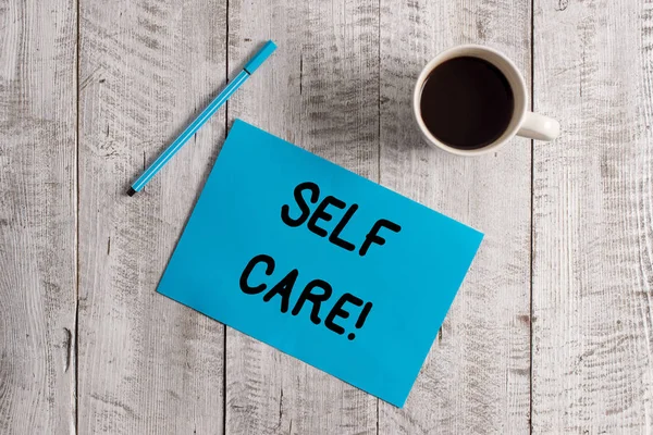 Escrita de mão conceitual mostrando Self Care. Foto de negócios mostrando a prática de tomar medidas preservar ou melhorar a própria saúde Pastel Colour papel e caneta com xícara de café na mesa de madeira . — Fotografia de Stock