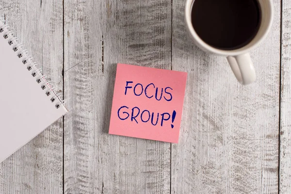 Word writing text Focus Group. Business concept for showing assembled to participate in discussion about product Stationary placed next to a cup of black coffee above the wooden table. — Stock Photo, Image