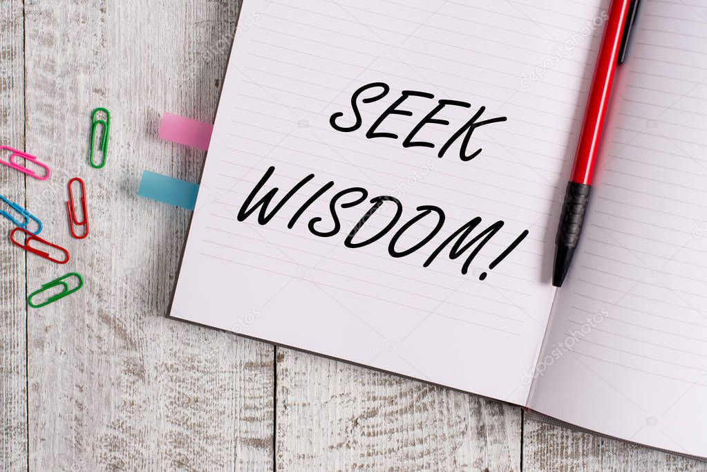 Conceptual hand writing showing Seek Wisdom. Business photo text ability to think act using knowledge experience understanding Notebook stationary placed above classic wooden backdrop.