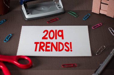 2019 eğilimleri gösteren metin işareti. Kavramsal fotoğraf genel yönü bir şey gelişen veya değişen makas ve yazma ekipmanları artı dokulu zemin üzerinde düz levha.