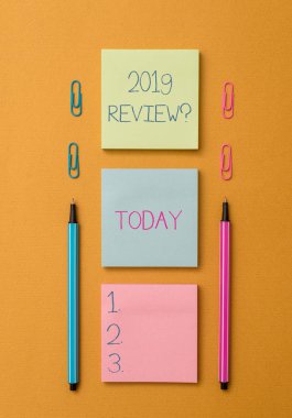 Word yazma metin 2019 yorum soru. Geçen yıl olaylar ana eylemleri veya iyi gösterileri hatırlamak için iş kavramı ön görünüm boş renkli yapışkan not iki tükenmez kalemler klipler sarısı arka plan.