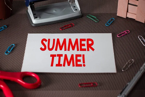 Sinal de texto mostrando hora de verão. Foto conceitual conseguir mais tarde luz do dia verão configuração relógios hora à frente Tesouras e equipamentos de escrita mais folha lisa acima do pano de fundo texturizado . — Fotografia de Stock