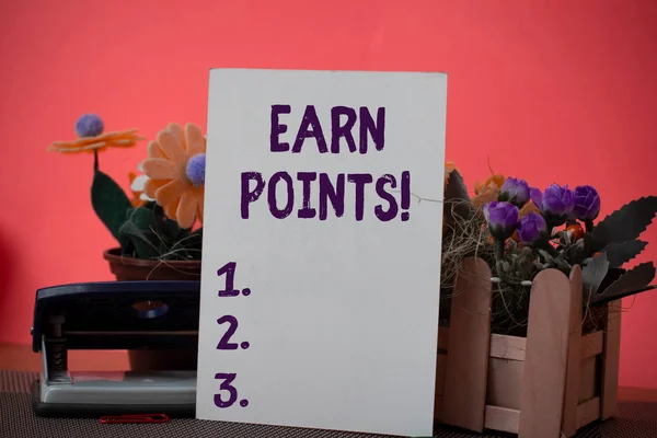 Text sign showing Earn Points. Conceptual photo collecting big scores in order qualify to win big prize Flowers and writing equipments plus plain sheet above textured backdrop.