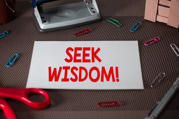 Text sign showing Seek Wisdom. Conceptual photo ability to think act using knowledge experience understanding Scissors and writing equipments plus plain sheet above textured backdrop.
