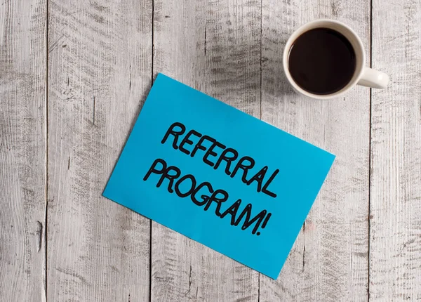 Tekstteken toont Referral programma. Conceptuele foto interne recruitment methode in dienst van organisaties pastel kleur papier geplaatst naast een kopje koffie boven de houten tafel. — Stockfoto